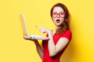 Surprised redhead girl with laptop